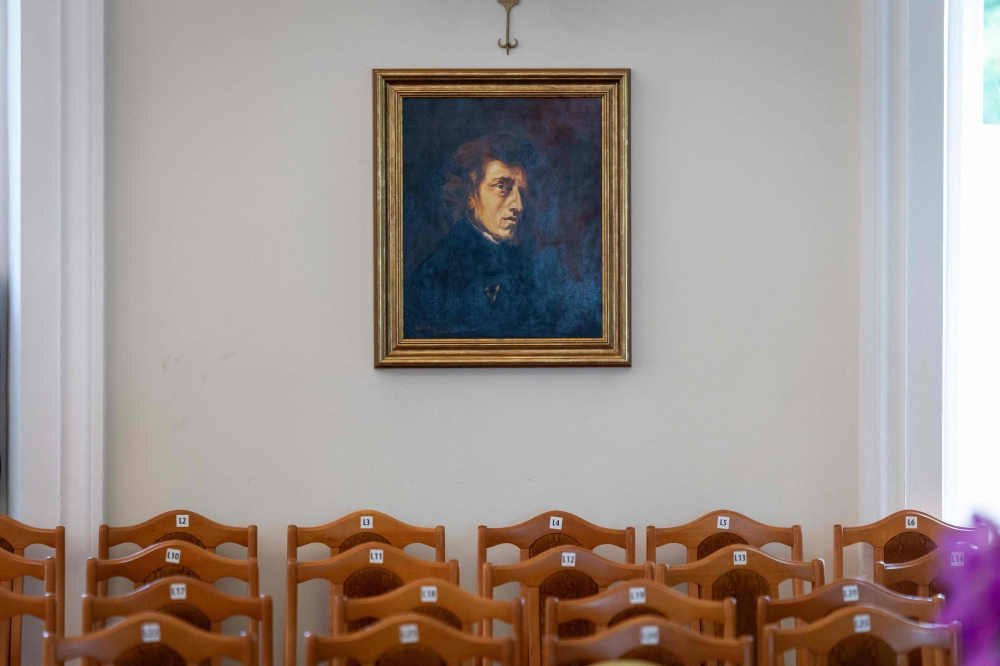 The chairs are arranged to welcome the audience under a portrait of Frederic Chopin in the concert hall of the so-called Chopin Manor on the second day of the 80th Duszniki International Chopin Piano Festival in Duszniki Zdroj, southwestern Poland, August 2, 2025. In 1826, when the town was part of Germany and known as Bad Reinerz that a 16-year-old Chopin gave here his first concert abroad. That performance inspired the founding of the festival in 1946. — AFP pic