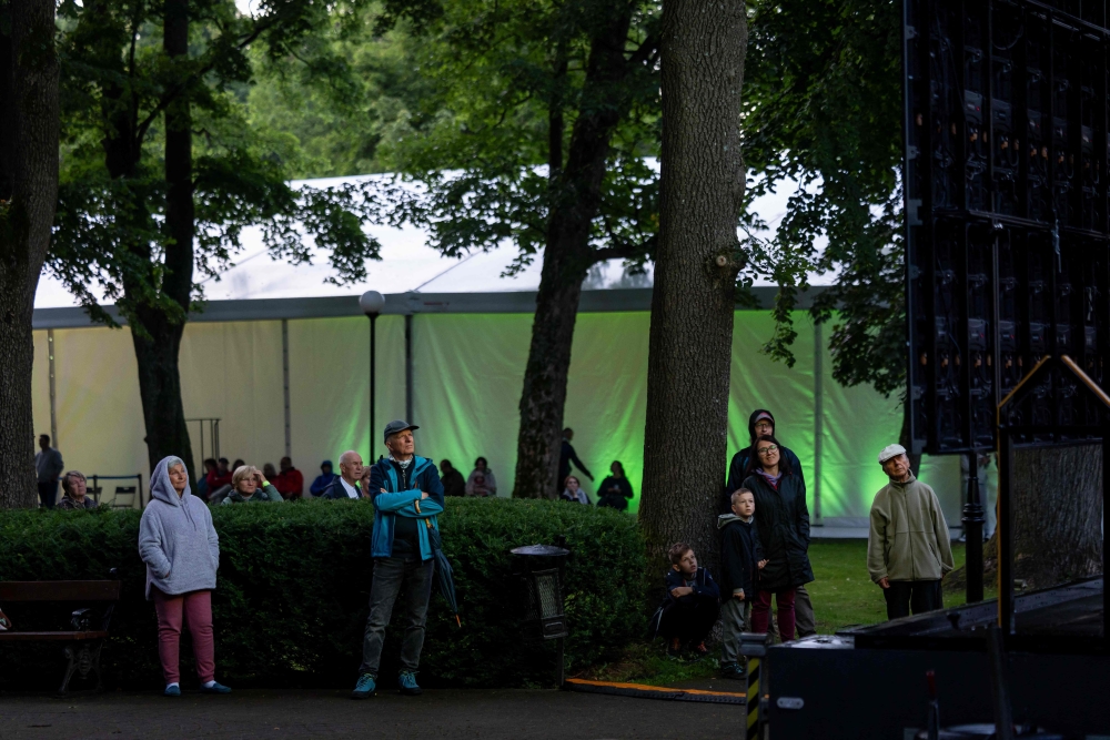 People in the park outside the concert tent listen to the music and watch the live broadcast on a giant screen during the opening concert of the 80th Duszniki International Chopin Piano Festival in Duszniki Zdroj, southwestern Poland, August 2, 2025. — AFP pic