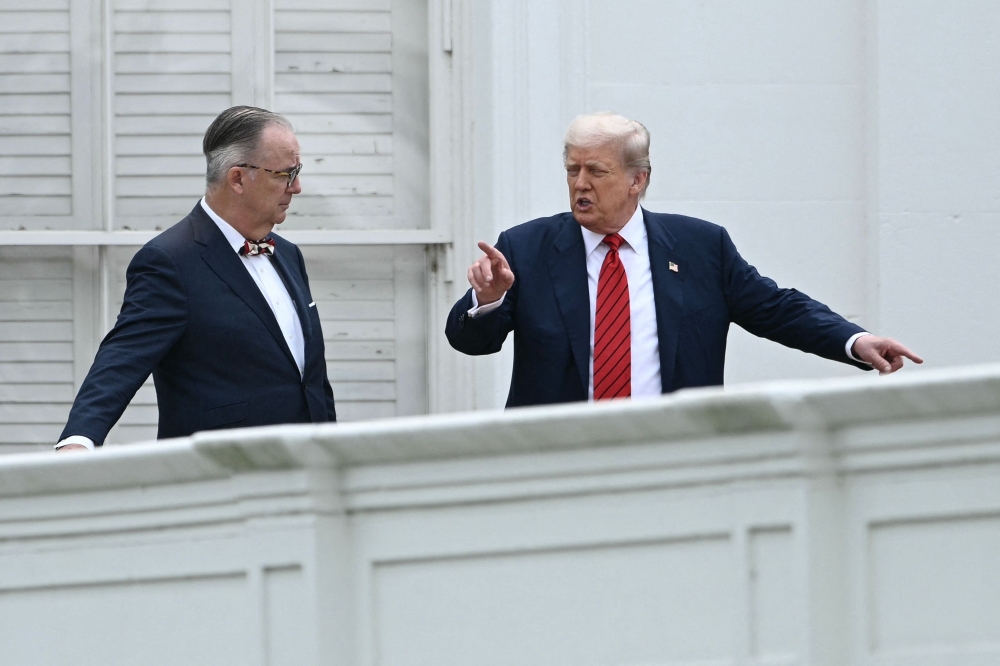 US President Donald Trump surveys the White House grounds from the rooftop in Washington, DC, August 5, 2025. — AFP pic