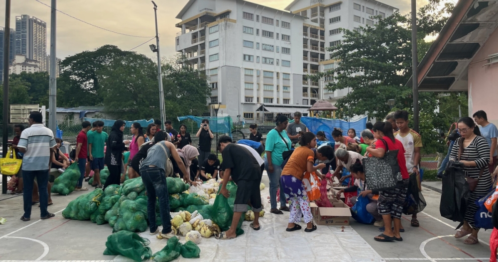 Volunteers arrange the produce from Pasar Borong Selayang prior to distribution to the Flat Hock Lock Mansion community. — Picture courtesy of Universiti Malaya