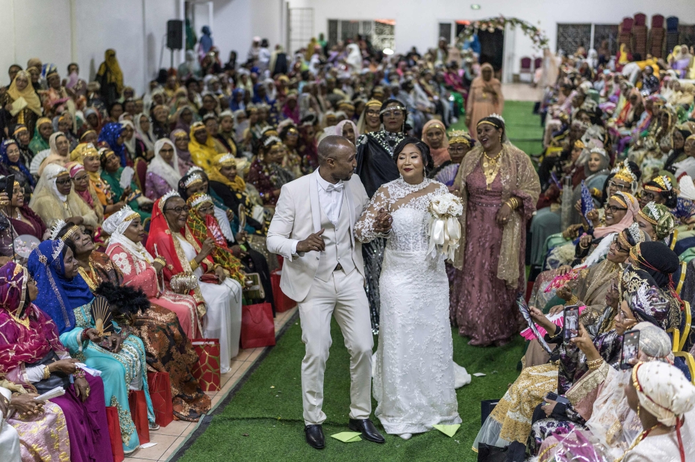 Franco Comoran Faid Kassim (centre left), who lives with his wife Faizat Aboubacar (centre right) in Reunion, dance during the Ukumbi, a women only reception marking the end of the Grand Mariage celebrations, at the Foyer des Femmes (a local venue dedicated to women only gathering) in Moroni, on July 20, 2025 during the evening reception of the couple's Grand Mariage.  This very expensive custom is often the goal of a lifetime and attracts scores of members of the Comorian diaspora who travel back to the archipelago to honour the tradition. — AFP pic 