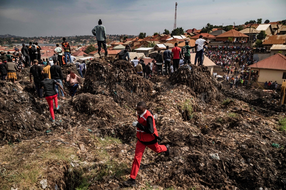 A Red Cross officer runs for help following a landfill collapse in Kampala on August 10, 2024. — AFP pic 