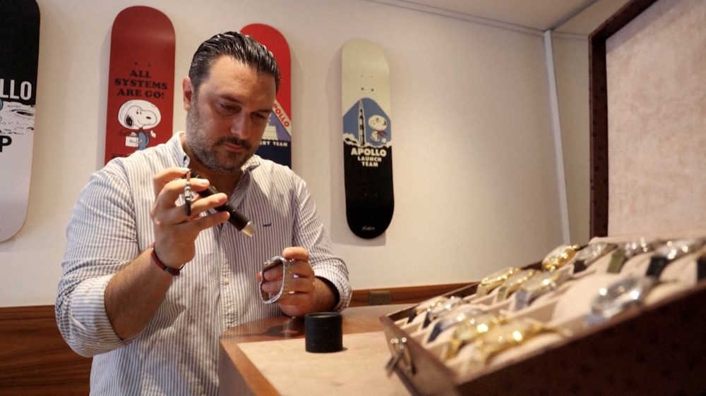 Sacha Davidoff, co-owner of vintage watch store Davidoff Brothers, examines a watch at his store, as the US implemented a crippling import tariff on Swiss goods on Thursday, in Geneva, Switzerland, August 7, 2025, in this still image taken from video. — Reuters pic 