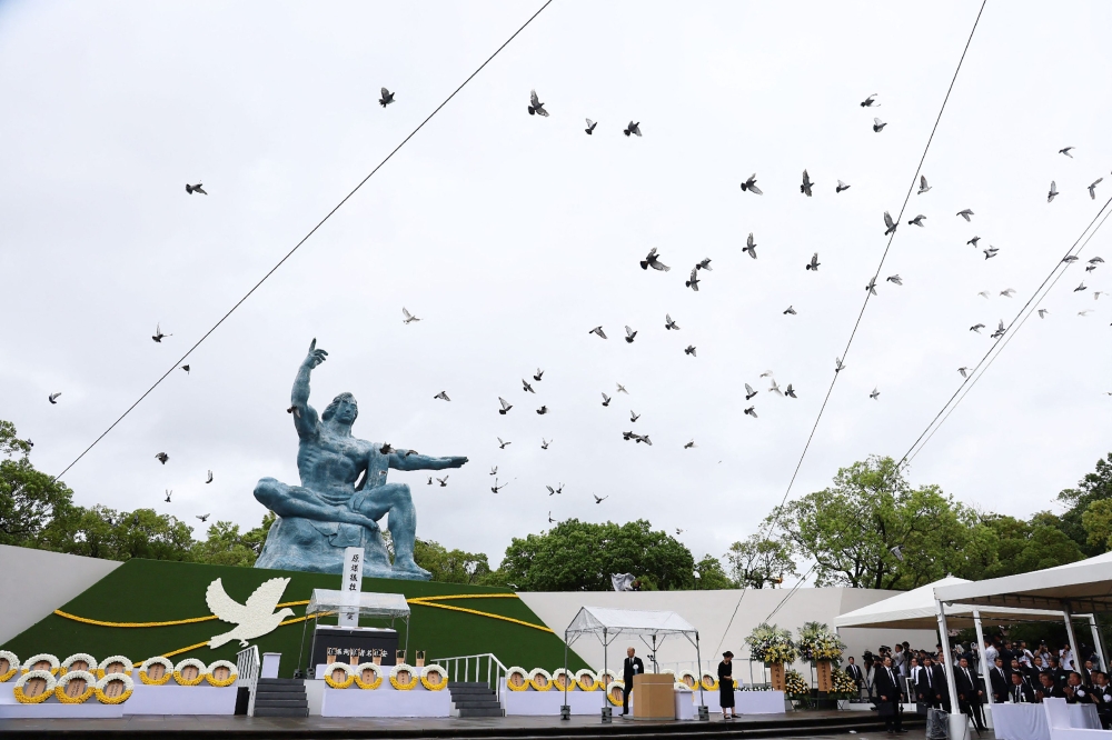 Doves fly past the ‘Peace Statue’ after being released into the air during the annual memorial ceremony for the victims at the Peace Park in Nagasaki on August 9, 2025, to mark the 80th anniversary of the atomic bombing during WWII. — AFP pic