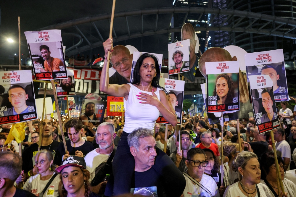 Einav Zangauker, mother of Israeli hostage Matan Zangauker, sits on the shoulders of Michel Illouz, father of fallen hostage Guy Illouz, at a demonstration in Tel Aviv on August 9, 2025. — AFP pic