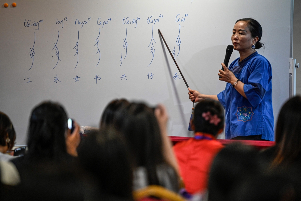 ‘Nushu’ instructor Jiang Yanying conducting a pronunciation lesson in a hotel conference room repurposed as a temporary classroom in Jiangyong county, southern China’s Hunan province. — AFP pic 