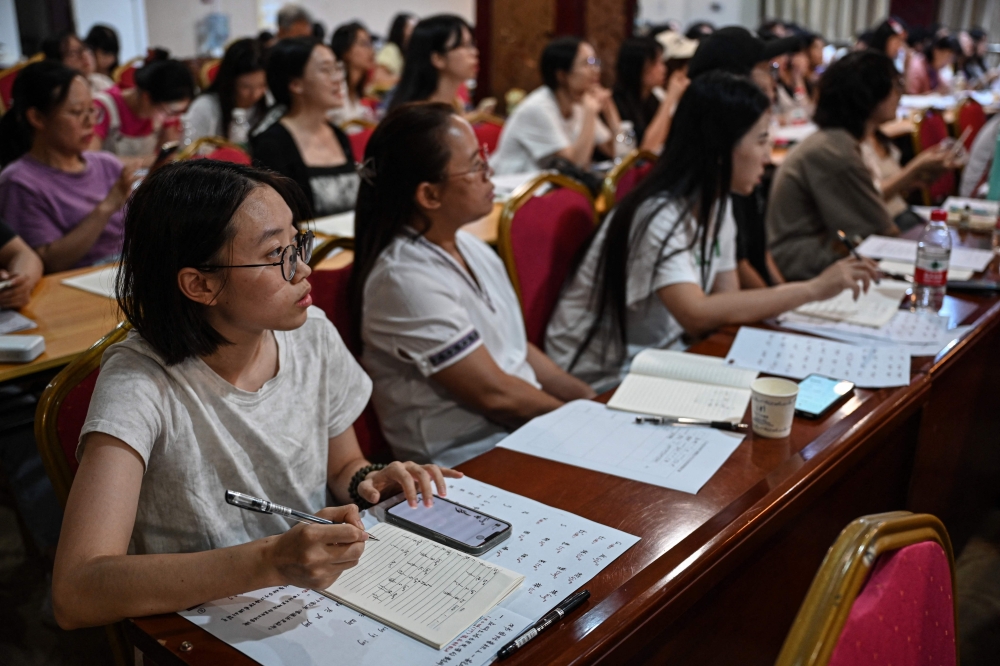 People learning ‘Nushu’ pronunciation in a hotel conference room repurposed as a temporary classroom in Jiangyong county, southern China’s Hunan province. — AFP pic 