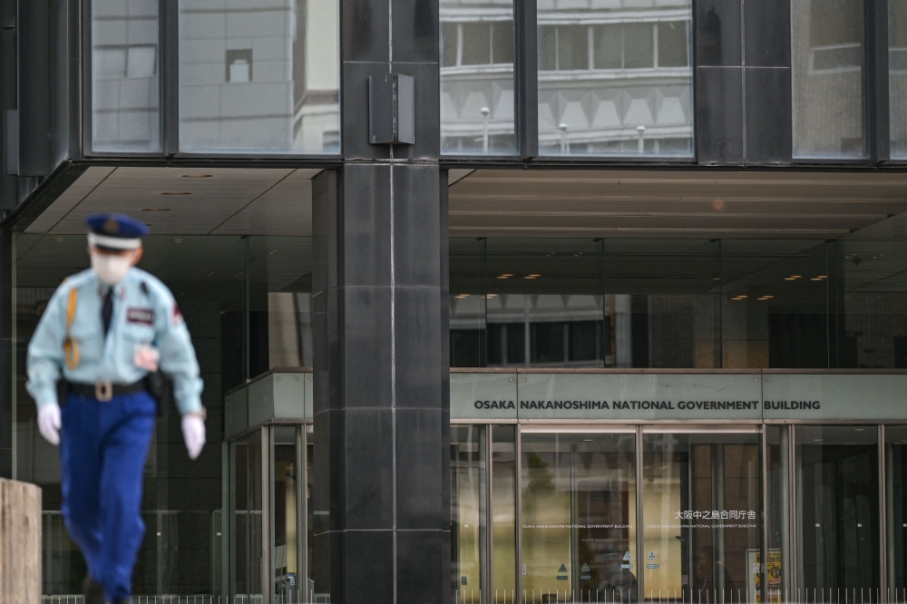This photo taken on May 27, 2025 shows a security guard walking outside the government building housing the Osaka District Public Prosecutor’s Office in the city of Osaka. — AFP pic 