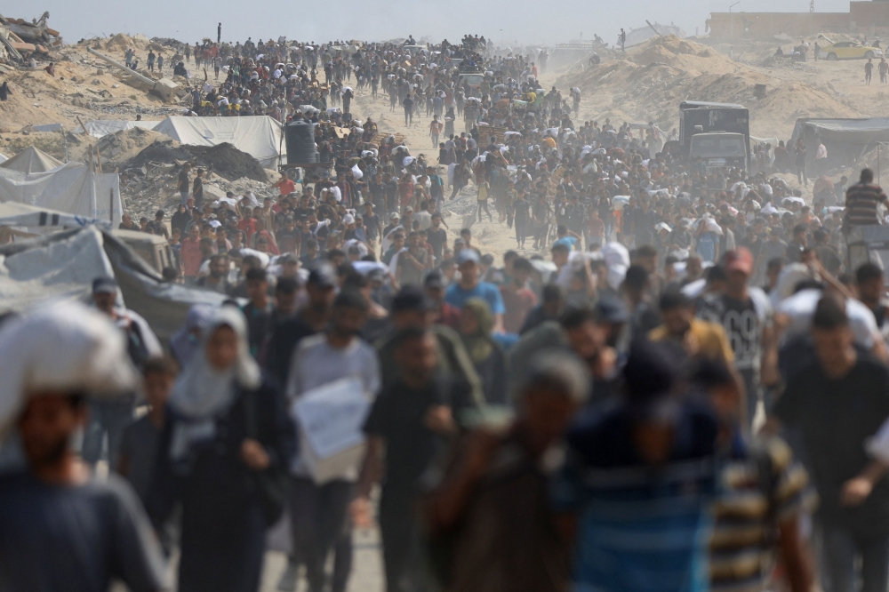 Palestinians carry aid supplies they collected from trucks that entered Gaza through Israel, in Beit Lahia, in the northern Gaza Strip August 10, 2025. — Reuters pic 