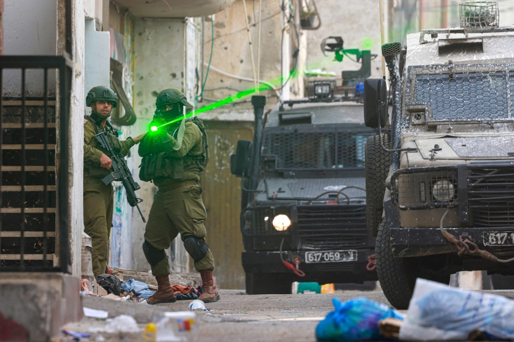 An Israeli soldier aims his weapon during a raid at the Balata refugee camp east of Nablus city in the occupied West Bank on August 11, 2025. Violence in the West Bank, which Israel has occupied since 1967, has surged throughout the Gaza war that began in October 2023. — AFP pic 