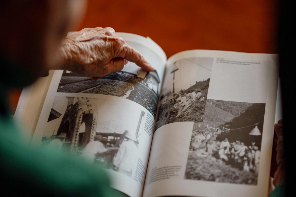 Survivor of Japanese camps during World War II and psychologist Tineke Einthoven, 87, looks at photographs at her home in Monaco, on January 13, 2025. — AFP pic
