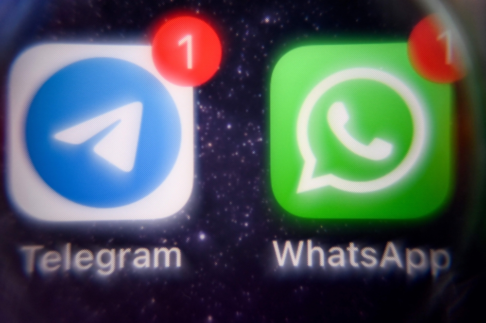 This photograph taken on March 23, 2022 shows the mobile messaging and call service Telegram logo and US instant messaging software Whatsapp logo on a smartphone screen in Moscow. Russia announced curbs on calls on the WhatsApp and Telegram messenger apps on August 13, 2025, saying that this was necessary to fight criminality, state media reported. — AFP pic 