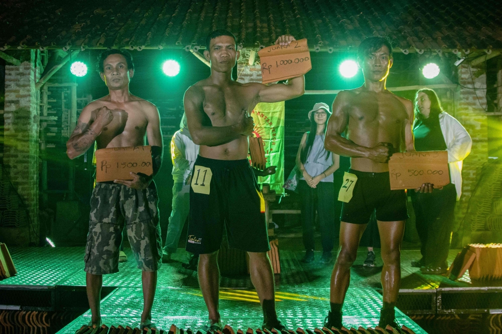 Winners pose with roof tiles showing the prize money during a traditional bodybuilding competition at a roof tile factory in Jatiwangi, West Java, August 11, 2025. — AFP pic