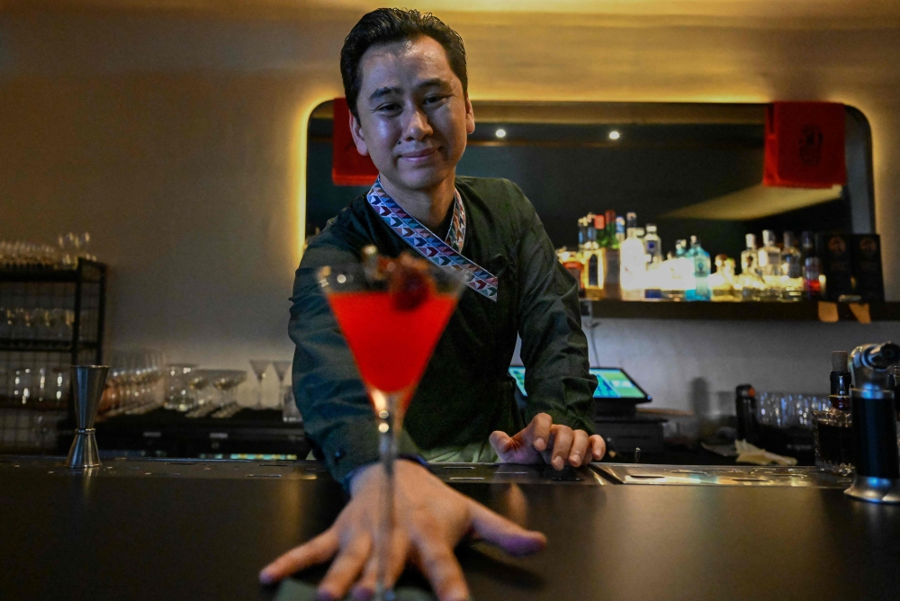 Abhishek Tuladhar, founder of cocktail bar and restaurant Barc, serves a drink with a slice of titaura, a local tangy and spicy hog plum treat, in a martini glass in Kathmandu July 2, 2025. — AFP pic