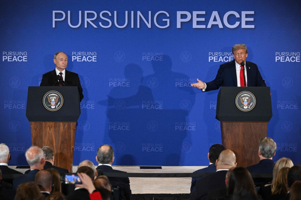 US President Donald Trump (right) gestures toward Russian President Vladimir Putin as they deliver a joint press conference after participating in a US-Russia summit on Ukraine at Joint Base Elmendorf-Richardson in Anchorage, Alaska August 15, 2025. — AFP pic