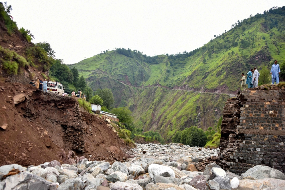 Onlookers gather near a destroyed bridge after flash floods on the outskirts of Muzaffarabad, the capital of Pakistan-administered Kashmir, on August 15, 2025. — AFP pic