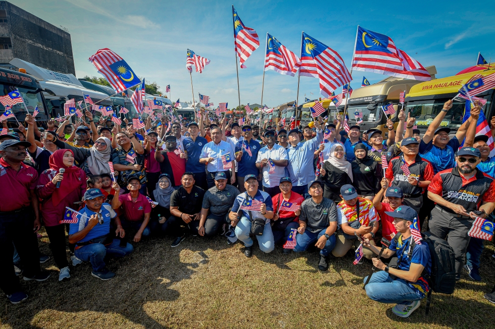 Transport Minister Anthony Loke (centre) poses for photos after handing over the Jalur Gemilang to 100 haulier representatives at the Port Klang Community Jalur Gemilang Programme at the Port Klang Authority’s Social and Recreation Club building today. — Bernama pic