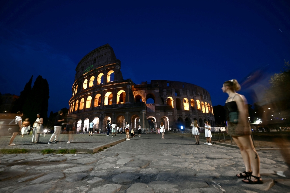 People walk in front of the Colosseum in central Rome August 13, 2025. — AFP pic
