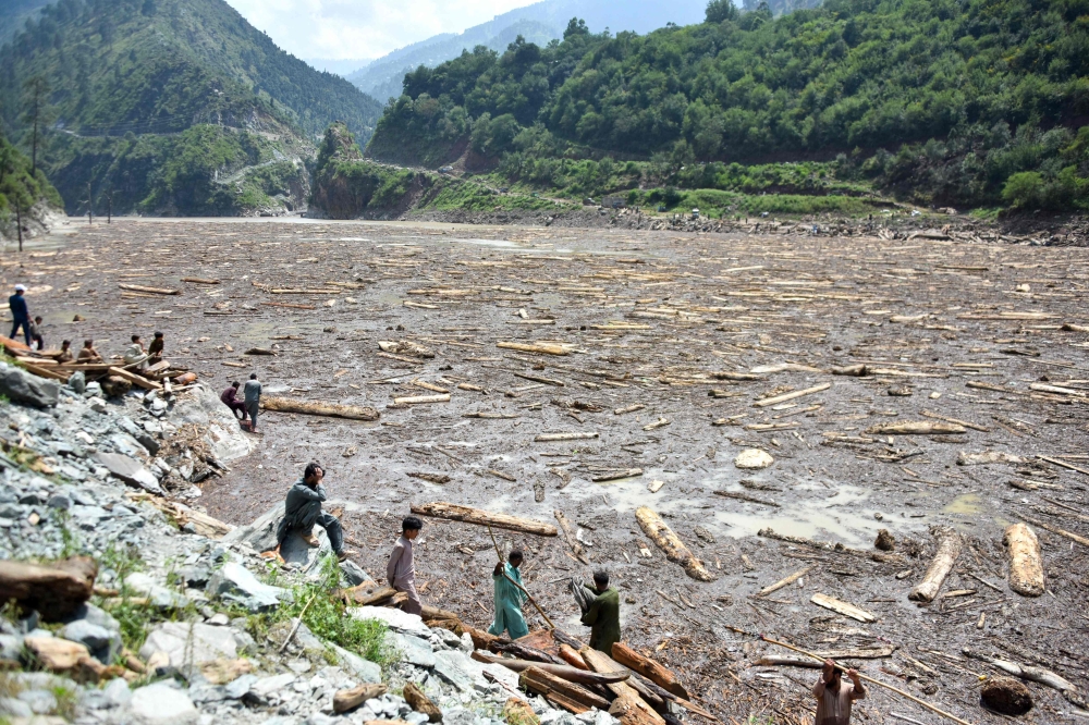 Locals collect wood from Noseri Dam near Muzaffarabad, the capital of Pakistan-administered Kashmir, on August 16, 2025, a day after flash floods. — AFP pic