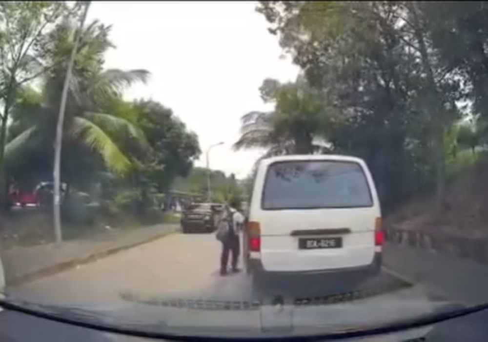 A screengrab from the video showing a boy attempting to board the moving vehicle.