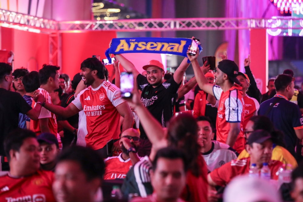 Thivagaran and his Biryani Rice jersey seen celebrating Arsenal's win over United with fellow Gunners at Strand Mall.  — Picture courtesy of Astro