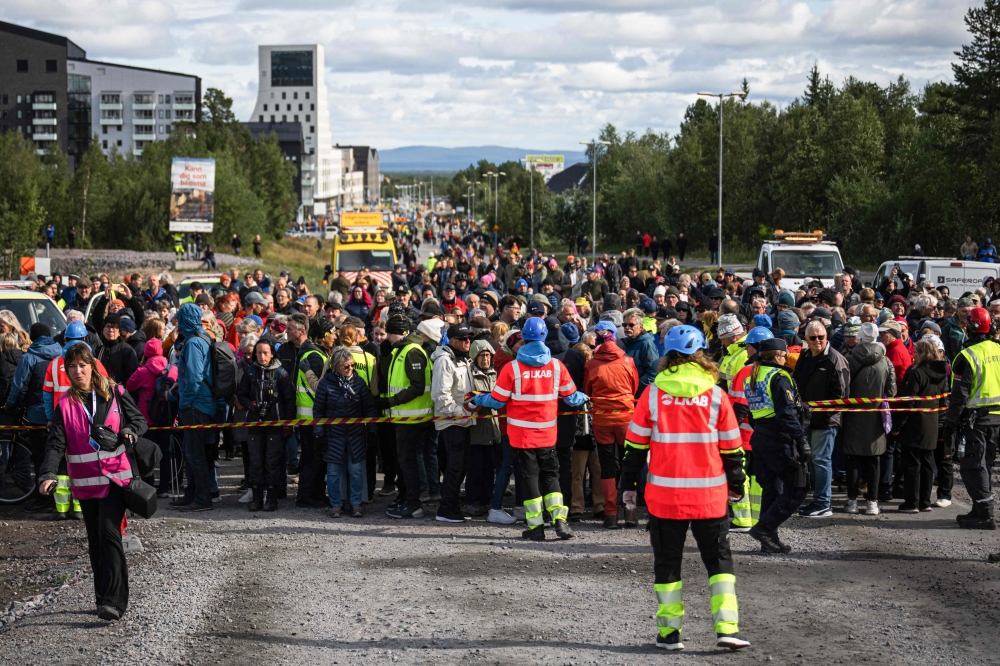 People gather at the new city centre to watch the wooden Kiruna Church as it arrives to its final location after a two-day move from the old town, in Kiruna, northern Sweden, August 20, 2025. — AFP pic