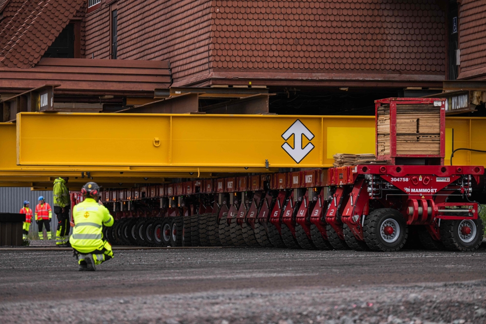 Workers use a remote controlled flatbed trailer with 224 wheels in total to move the wooden Kiruna Church, in Kiruna, Sweden, August 20, 2025. — AFP pic