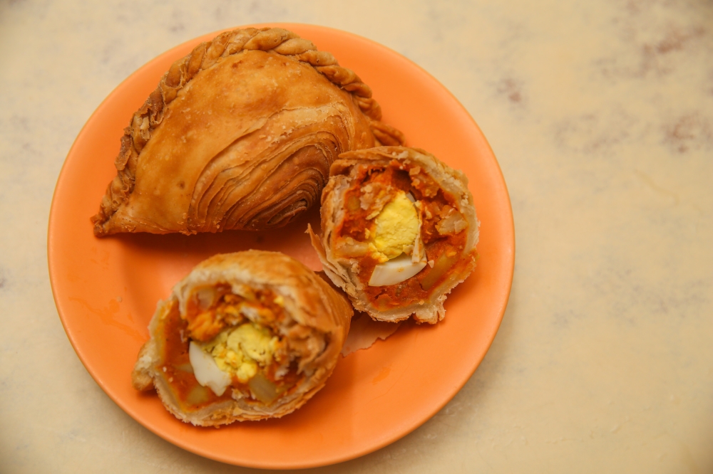 Thousand Layer Curry Puff uses two different doughs to create the flaky layers of the plump curry puff stuffed with curry, diced chicken and a hard-boiled egg. — Picture by Choo Choy May