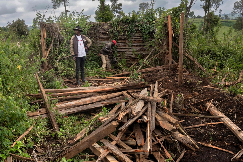 Human rights activist Fred Ngusilo (left) and a relative search through the ruins of their grandfather’s house in the Mau Forest, Narok County, on August 16, 2025. — AFP pic
