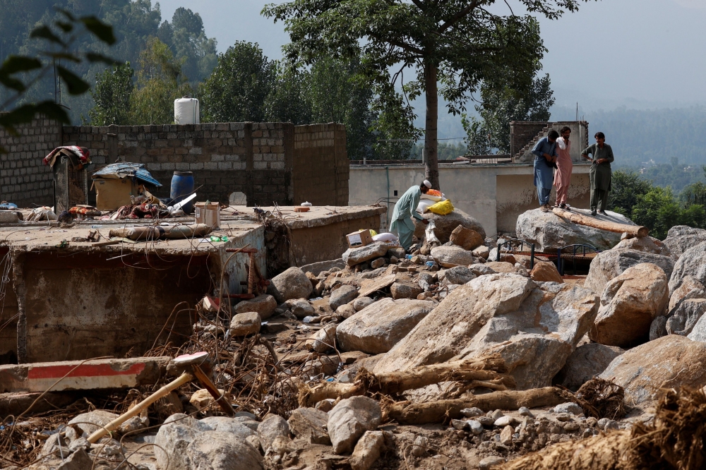 Residents stand near a damaged house, following a storm that caused heavy rains and flooding in Qadir Nagar area, in Buner district, Khyber Pakhtunkhwa province, Pakistan, August 21, 2025. — Reuters pic