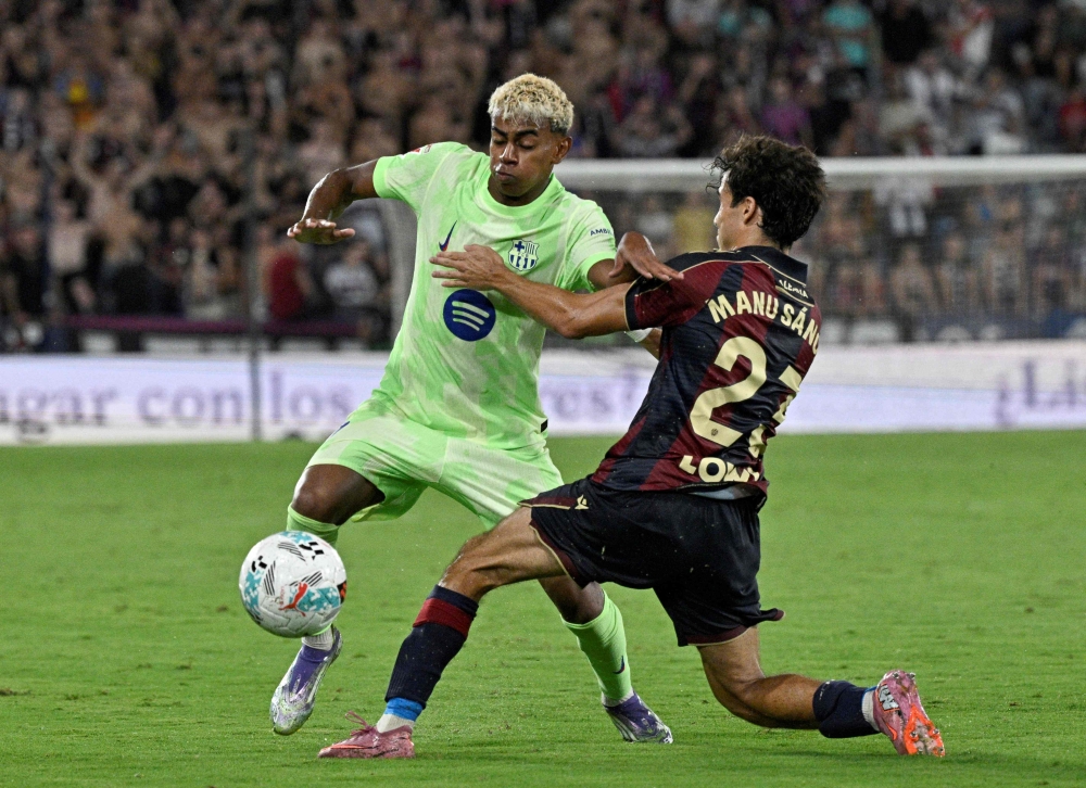 Barcelona's Spanish forward #10 Lamine Yamal fights for the ball with Levante's Spanish defender #23 Manu Sanchez during the Spanish league football match between Levante UD and FC Barcelona at Ciutat de Valencia Stadium in Valencia on August 23, 2025. — AFP pic