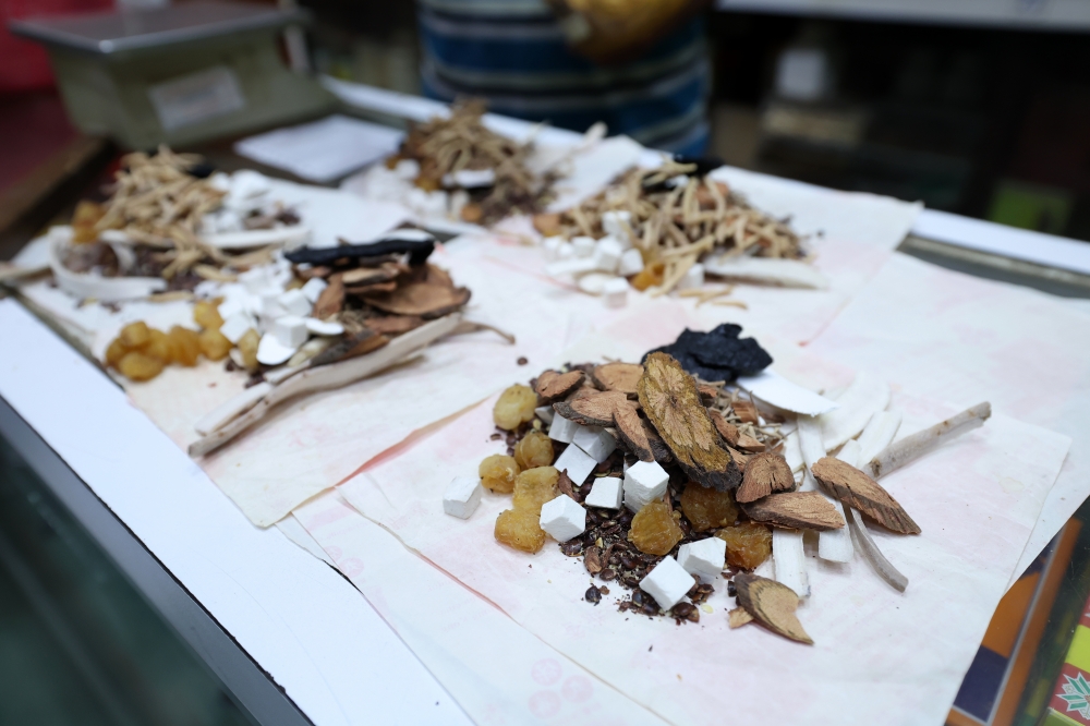 A worker at the 83-year-old Kedai Ubat Kien Fatt in Kuala Lumpur prepares self-made traditional medicine for customers, as the heritage shop continues to attract loyal patrons and curious tourists recently. — Bernama pic