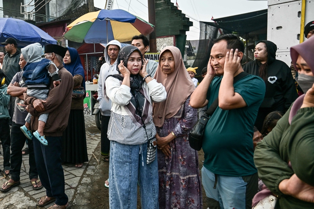 This photo taken on August 9, 2025 shows people covering their ears as a truck mounted with a tower of subwoofers drives past during a ‘sound horeg’, which loosely means to move or vibrate in Javanese, held as part of Indonesia’s 80th Independence Day celebrations in Malang, East Java. — AFP pic