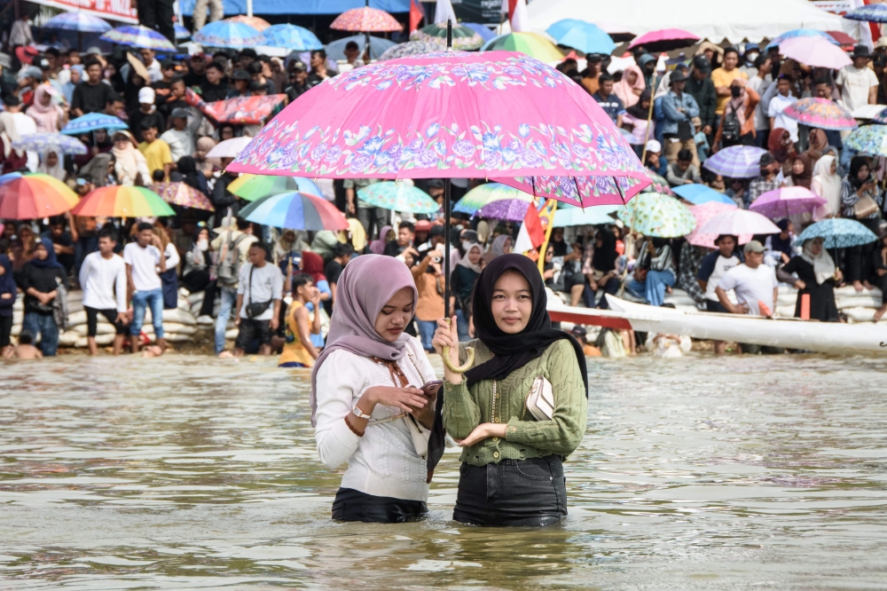 Spectators watch the Pacu Jalur longboat race festival on the Kuantan River in Kuantan Singingi Regency, Riau Province, on August 23, 2025. — AFP pic