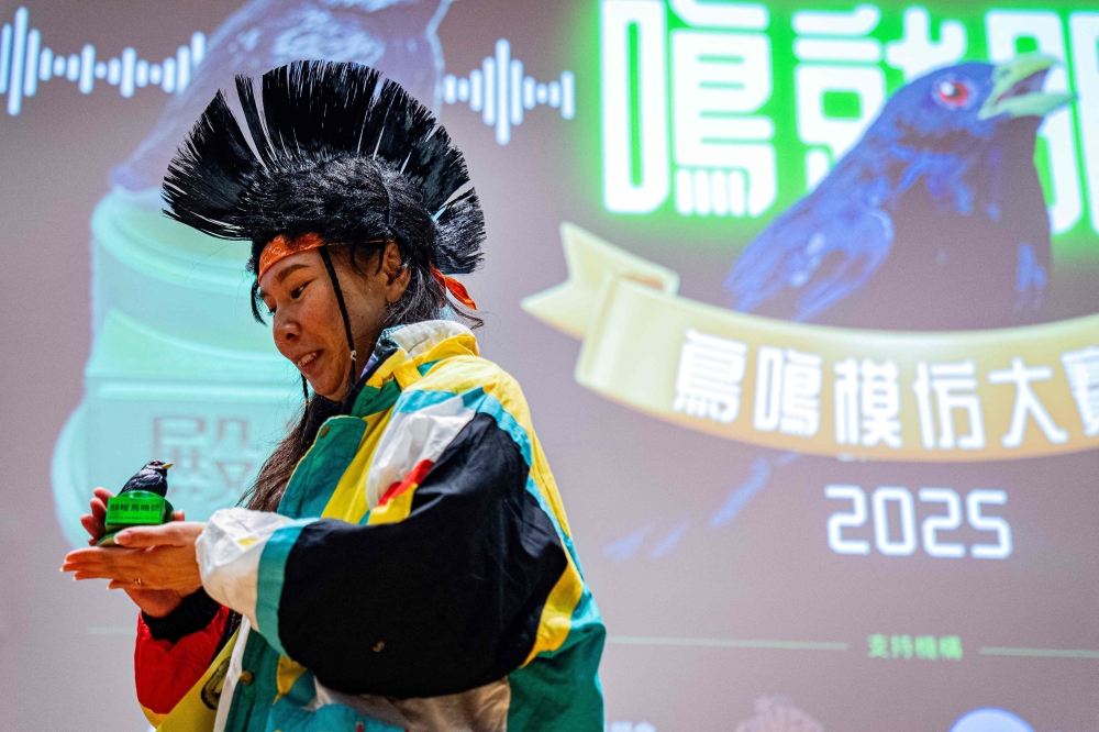 A participant looks at her trophy during the Hong Kong Bird Watching Society’s bird call competition at the University of Hong Kong on August 23, 2025. — AFP pic