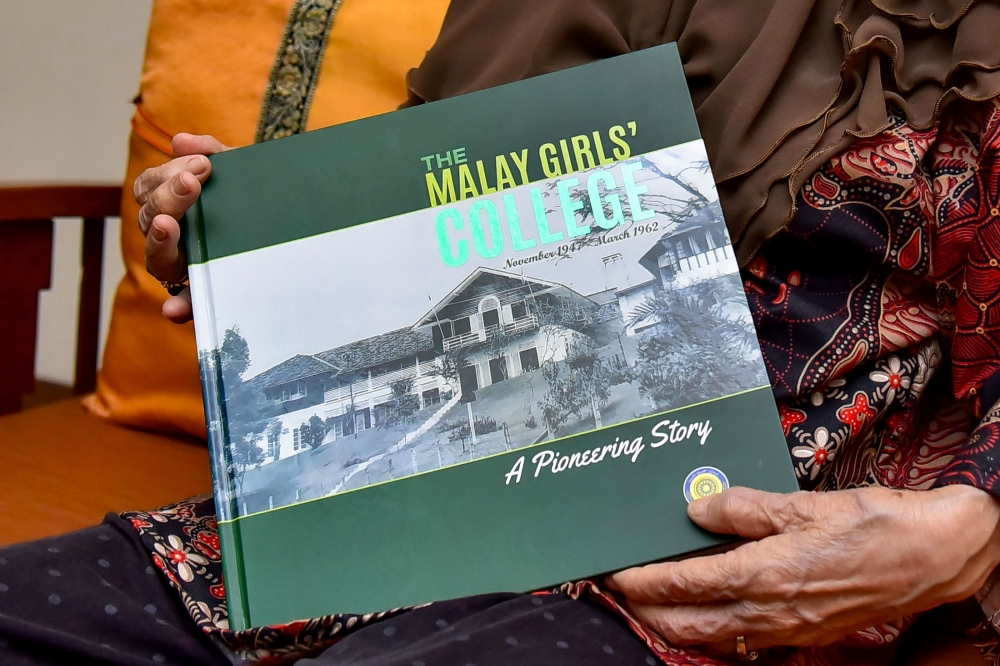 Former President of the Malaysian Linguistic Association, Prof. Emeritus Datuk Nik Safiah Karim, showing a book on The Malay Girls’ College during an interview on language as a unifying force and the development of the Malay language over the past decade. — Bernama pic