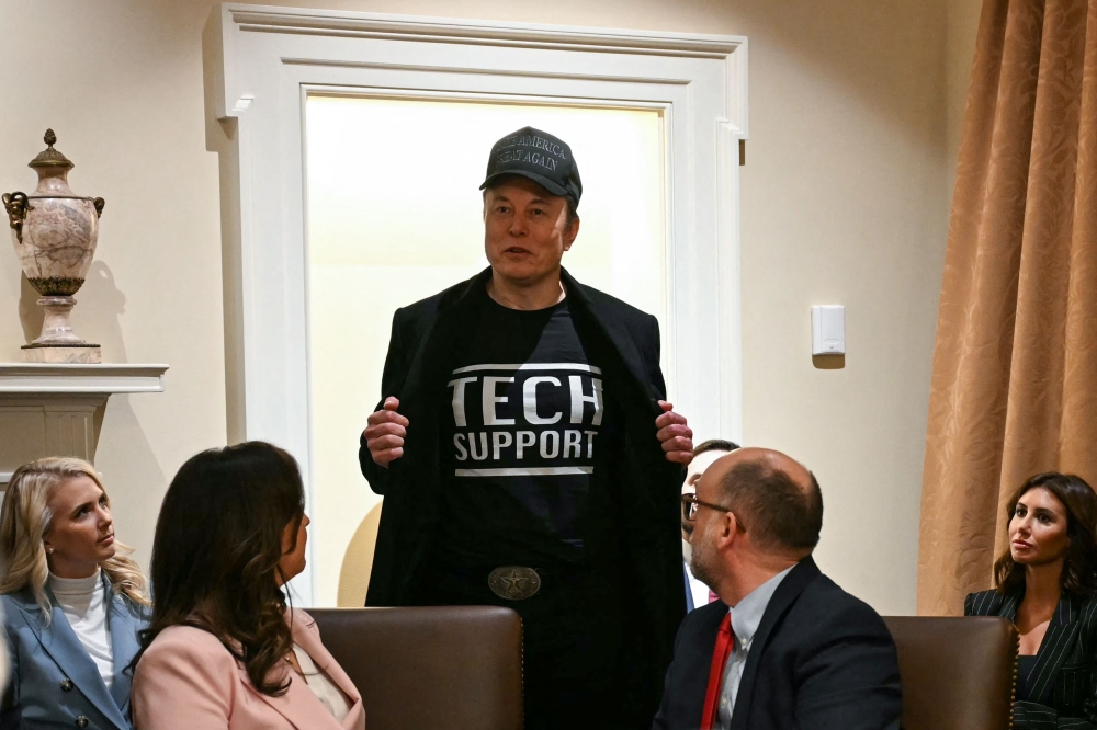 Elon Musk wears a shirt that says 'Tech Support' as he speaks during a cabinet meeting with US President Donald Trump at the White House in Washington, DC, on February 26, 2025. — AFP pic