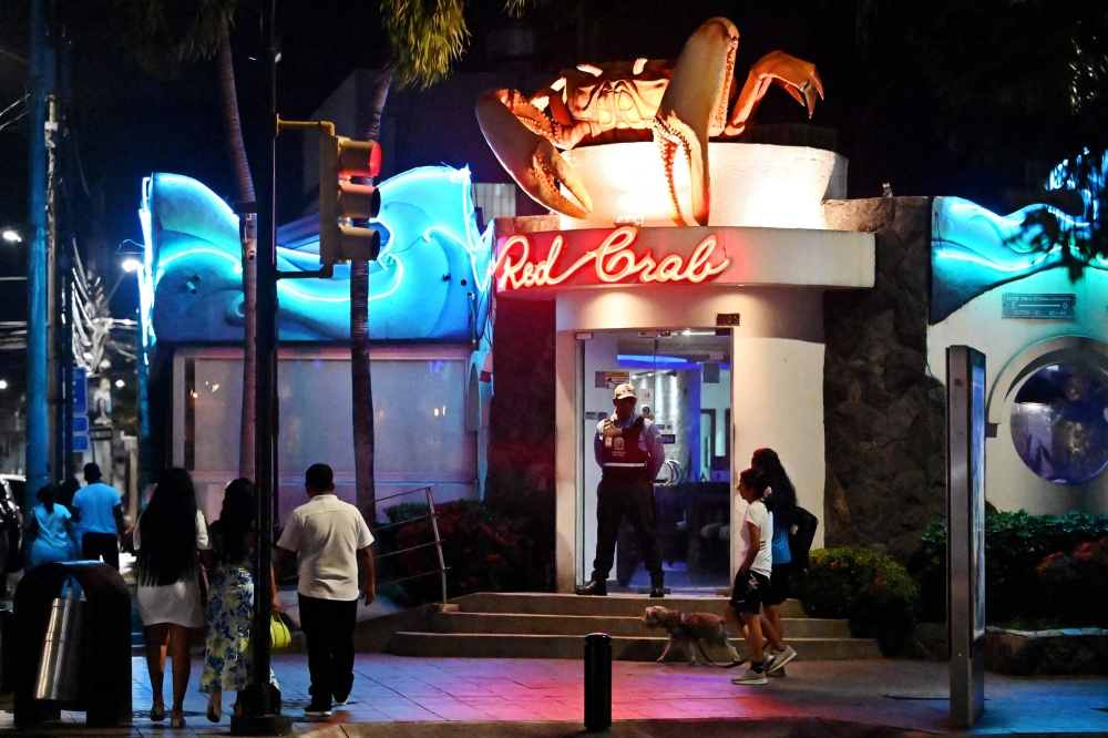 A security guard stands guard at the entrance of a restaurant in Guayaquil, Ecuador on August 9, 2025. — AFP pic