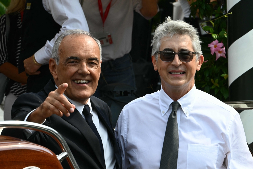 Director of Venice Film Festival Alberto Barbera (L) and the president of the jury US film director Alexander Payne arrive at the Excelsior pier on the eve of the 82nd Venice International Film Festival at Venice Lido today. — AFP pic