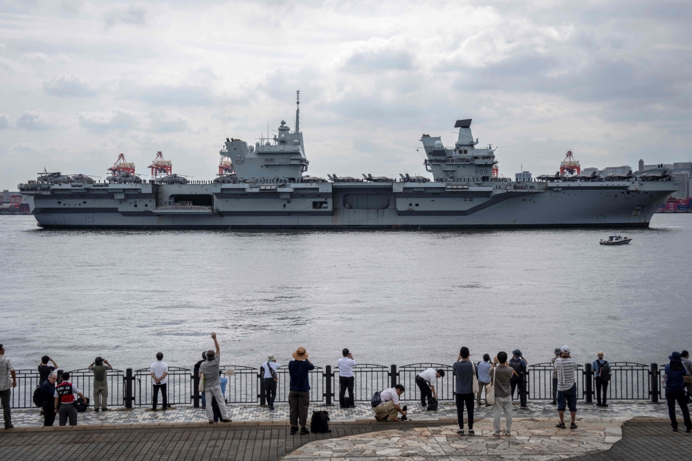 People take photographs of British aircraft carrier HMS Prince of Wales arriving at Tokyo Bay August 28, 2025. — AFP pic