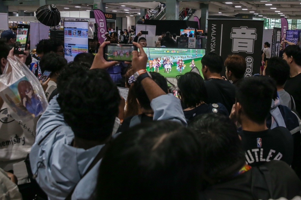 Pretty Derby fans and players gathered around to watch an ongoing horse race at AniManGaki 2025 held at the Mines International Exhibition and Convention Centre in Seri Kembangan August 24, 2025. — Picture by Yusof Isa