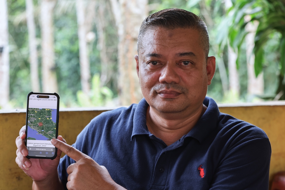 Kampung Tengah resident Ahmad Asri Talib, 52, shows the MetMalaysia’s report after weak tremors were felt in Segamat, Johor early in the morning of August 24, 2025. — Bernama pic