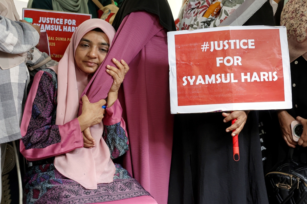Ummu Haiman Bee Daulatgun, mother of Syamsul Haris Shamsudin, is consoled by a relative during his exhumation in Semenyih August 29, 2025. — Bernama pic