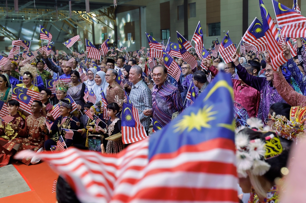 Prime Minister Datuk Seri Anwar Ibrahim waves the Jalur Gemilang alongside attendees at the 2025 National Day Address held at the Malaysia Agro Exposition Park Serdang (Maeps) in Serdang August 30, 2025. — Bernama pic