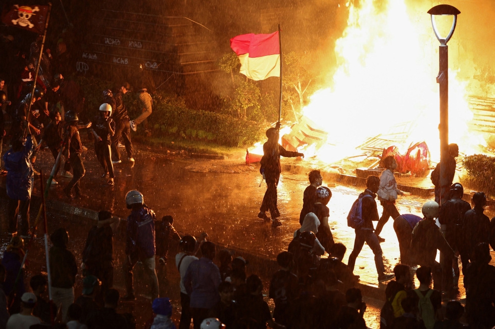 Protesters carry an Indonesian flag and a flag from Japanese anime ‘One Piece’ during a protest outside Jakarta police headquarters August 29, 2025. — Reuters pic