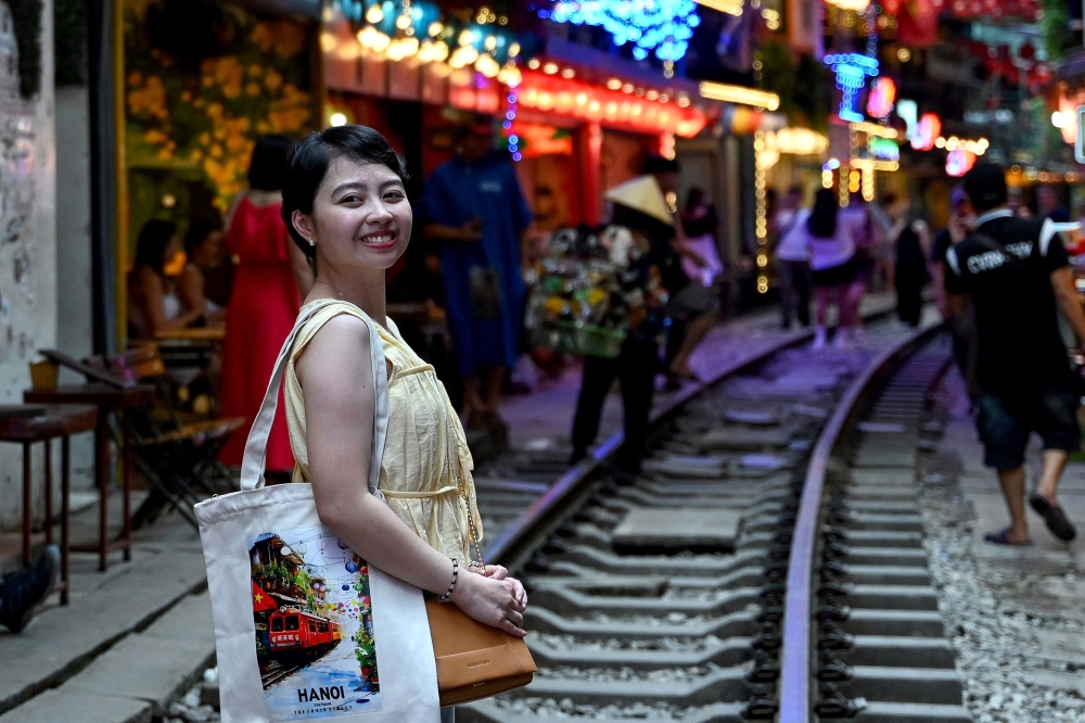 A tourist poses for a photo along a railway track in central Hanoi August 18, 2025. — AFP pic