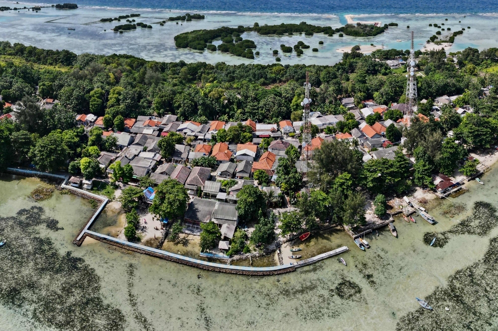 In this aerial picture taken on February 22, 2023, a concrete embankment, used to stem rising sea levels, is seen around part of Pari island in the Thousand Islands cluster. — AFP pic