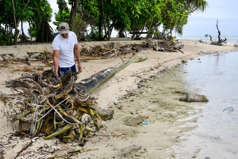 In this picture taken on February 23, 2023 resident Sartono helps to clear a beach full of debris on Pari island in the Thousand Islands cluster. — AFP pic