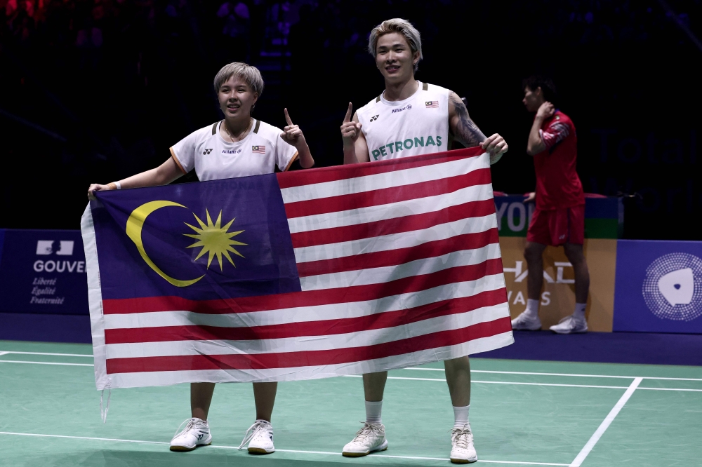 Malaysia’s Chen Tang Jie and Toh Ee Wei (left) hold the Jalur Gemilang as they celebrate beating  China’s Jiang Zhen Bang and Wei Ya Xin in the mixed doubles final match at the Badminton BWF World Championships in Paris August 31, 2025. — AFP pic