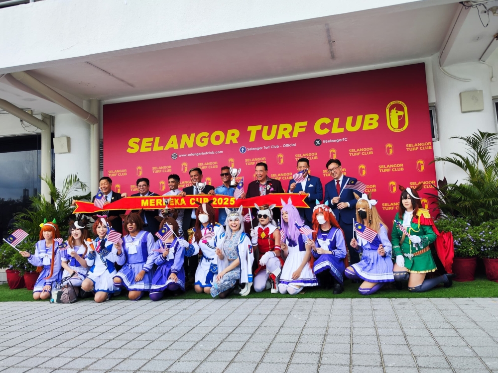 Cosplayers pose for a group photo with a victorious jockey and racehorse at the winner’s enclosure. — Picture by Kenneth Tee
